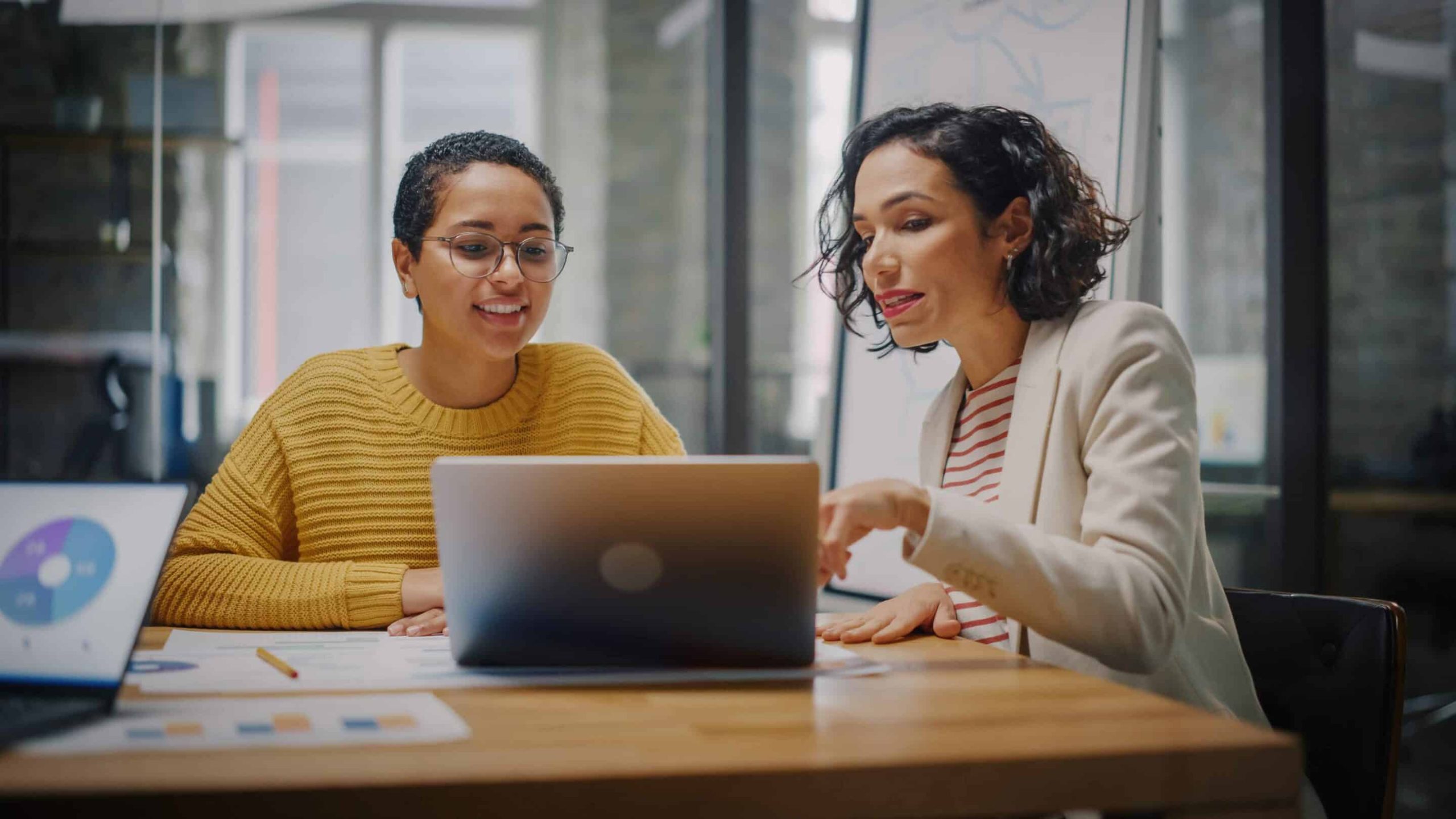 Zwei Personen besprechen Berichte am Laptop